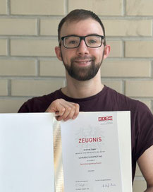 Andreas Zagler mit Zeugnis nach bestandener Lehrabschlussprüfung