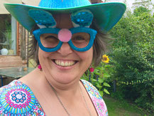 Susanne Christine Drdla mit Faschingsbrille und Faschingshut, lachend. 