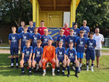 Junge schießt Ball zum Trainer