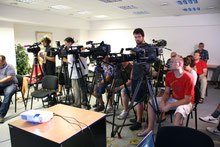 Blick in die Runde der Journalisten und Journalistinnen während einer Pressekonferenz, in der ersten Reihe sind sechs Kameras aufgebaut, dahinter stehen die Kameraleute, auf den Stühlen der nächsten Reihen sitzen aufmerksame Personen.
