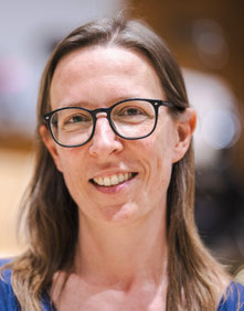 Das Bild zeigt Eva Regul mit Brille und schulterlangen Haaren.
