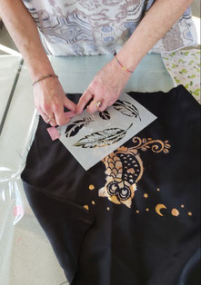 Photo de mains en train d'utiliser un pochoir pour peindre sur du tissu. Atelier loisirs creatifs de Lideatelier, savoie, chambery