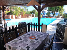 Terrasse bungalow n°4 avec vue sur la piscine – coin repas, table, chaises