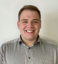 Portraitfoto von Jan Weimann vor einer weißen Wand.
