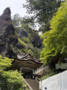 岩肌と木造の神門が並ぶ、自然と建築が調和した神社の風景。