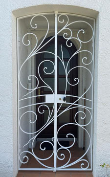 portail en acier fer forgé faconnage traditionnel avec volutes toiles festonnées motif fonte et fer de lance teinte rouille