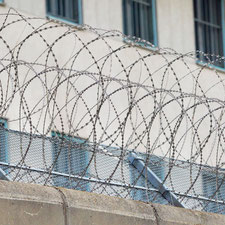 Eine Mauer mit Nato-Draht vor einer Justizanstalt in Wien