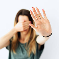 Eine Frau streckt abwehrend die Hand aus