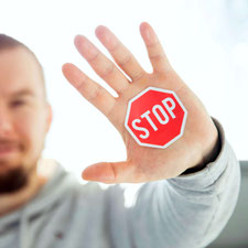 Ein Mann hält abwehrend die Hand vor sich.