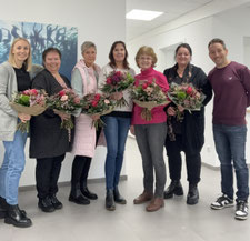 Die Jubilarinnen stehen nebeneinander und halten einen Blumenstrauß in der Hand, ganz rechts steht der Geschäftsführer
