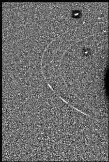 Eine Voyager-Weitwinkelaufnahme vom 23. August 1989, zwei Neptunmonde, darunter Larissa (oben), die beiden Hauptringe des Neptun und die drei der vier Ringbögen zeigt.