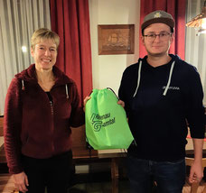 Abteilungsleiterin Eva Bendixen überreicht den LG Rei-schenau-Zusamtal Beutel mit Geschenk an Magnus Prohm.