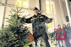Revierförster Rolf Esslinger agiert als Auktionator bei der Christbaumversteigerung. Foto: Hansen