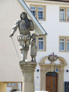 Der Kaltentaler - Georg Friedrich von Kaltental und die Waise Adiz - eine Beton-Plastik von Peter Lenk vor dem Durchgang zu Schloss Aldingen