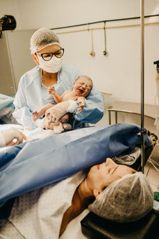 Mutter und Neugeborenes während eines Kaiserschnitts