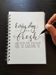 Karierter Block auf dem mit geschwungerner Schrift steht: Every day is a fresh start