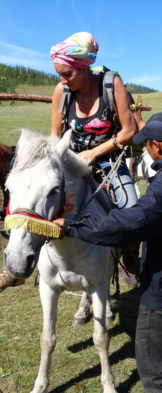 La montée en selle avec l'aide du guide mongol