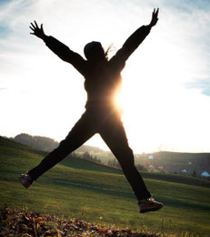 Person macht Luftsprung nach Erreichen von mehr Lebensqualität dank SBC-Coaching