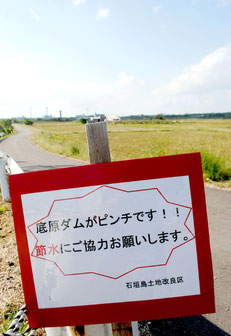 ほ場の近くに設置された節水を呼び掛ける看板=20日午後、石垣市新川