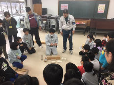 団体紹介③　お手本を見せ、子どもたちが注意点等を熱心に聞いている様子。
