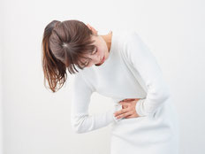 前川医院にご来院の、腹痛の女性患者のイメージです。腹痛の原因は様々ですので、内科的・外科的側面から診察します。