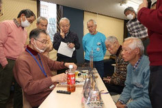 講師を取り囲んで製作方法の 説明を聴く受講者