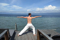 Mann macht Yoga vor Wasser für gesunden Körper