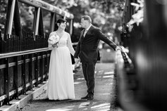 Photographe mariage Tarn-et-Garonne – couple de mariés marchant main dans la main sur un pont en noir et blanc