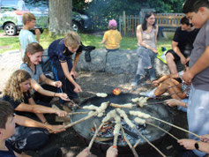 Stockbrot grillen am Lagerfeuer - nach dem Ferienlagerprogramm gibt es für alle eine verdiente Stärkung