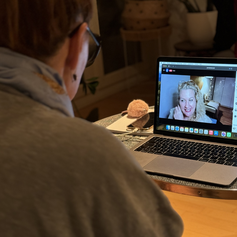 Eine Frau sieht sich im Dunkeln die online Lichtsitzung von der Dolmetscherin der Seele henrike Baumgartner an auf ihrem Laptop. Live und kostenfrei auf Youtube