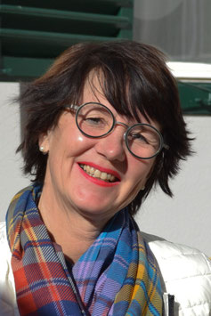 Portraitfoto von Barbara Nussbaumer-Grillitsch, Stome und Kontinenzberaterin. Sie hat kürzere Haare und eine runde Brille. Um den Hals trägt sie einen bunten Schal.
