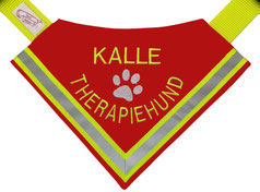 rotes Hundebandana mit Reflektorstreifen in neongelb, beschriftet mit Kalle Therapiehund,das Hundhalstuch hat in der mitte eine weiße Pfote eingestickt als Motiv. Man kann es mit einem Gurtband um den Hals legen und schließen.