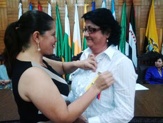 Kerly Torres, asambleísta por Manabí (Ecuador) impone la condecoración póstuma VIcente Rocafuerte de la Asamblea de la República en el pecho de la viuda del escritor Ubaldo Gil Flores.