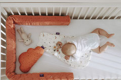 Baby im Kinderbett mit Bettschlange und Kuschelkissen Wolke von Träumeland