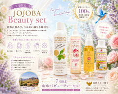 7月限定JOJOBA Beauty Setの広告画像。ラベンダーやバラの花々、青い鳥を背景に、ホホゴールド、オブライエンズシャンプー、ラララ ボディ＆ハンドソープ、ミスマリコが並ぶ女性向けデザイン。原種ホホバオイル100％の自然の恵みと、アリゾナ州ハクアハラヴァレーの美しい自然をイメージした華やかなPR画像。