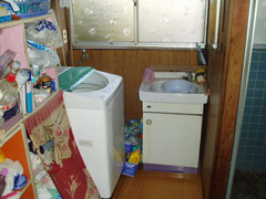 工事前　洗面所　配管位置が悪く洗濯機がきれいに収まらない状態でした。
