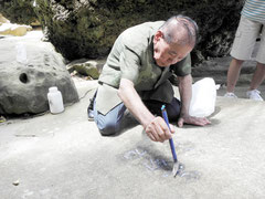 識名校長が刻んだ文字を凝固剤で保存する平田一雄会長=15日、忘勿石之碑
