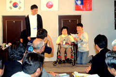 照屋さん(中央)と高野さん、韓国のイさん(左)が参加者宣言、大会への期待を膨らませた=レストラン八重福、大川