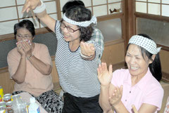 浦添商の得点シーンで、大喜びで踊り出すす関係者。左は感激の表情を見せる母の順子さん=16日午後、石垣市石垣の宮良監督の実家