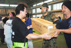 自衛隊員と市民が協力し、救援物資を屋内練習場に搬入する訓練を行った(29日午前)