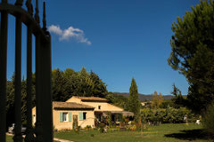 Vue sur la maison Le Petit Grain de la grille d'entrée