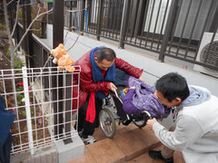 車椅子での参加者を階段から地下へ降ろしている写真