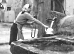 Une femme prenant de l'eau à la fontaine