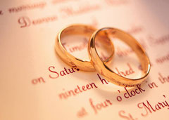 A set of wedding rings set on top of a wedding invitation