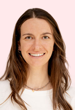 Ein Portrait von Laura Eichberger, Physiotherapeutin in der Praxis Octopus in Graz. Sie trägt ein weißes Shirt und eine Halskette, hat die Haare offen und blickt mit einem breiten Lächeln direkt in die Kamera.