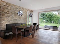 Wohnzimmer mit Holzboden, Holztisch, Glasfront zum Garten