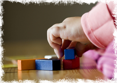 Kleinkind spielt mit Bausteinen bei den Glückskinder