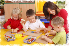 3 Kinder spielen Geschicklichkeitspuzzle mit einer Erzieherin