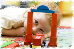 Junge schaut durch Tor auf Bausteinen