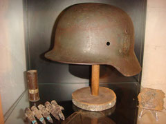 German M40 combat helmet found in Ste. Marie-du-Mont, related to a soldier of Grenadier Rgt. 919. The 13./Grenadier Rgt. 919 was in Brucheville. Also on the photo are a relic belt buckle also from Ste. Marie-du-Mont as well a part of a machine gun belt an